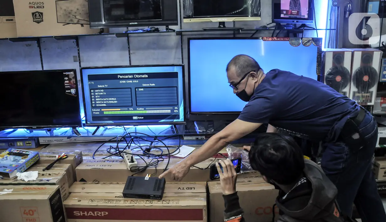 Pedagang memindai siaran TV Digital melalui Set Top Box (STB) di salah satu toko kawasan Glodok, Jakarta Barat, Kamis (3/11/2022). Penjualan STB TV Digital mengalami peningkatan hingga 60 persen usai pemerintah melalui Kementerian Komunikasi dan Informasi (Kominfo) secara resmi menghentikan siaran TV Analog atau Analog Switch Off (ASO) Jabodetabek pada 2 November 2022. (merdeka.com/Iqbal S. Nugroho)