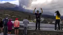 Wisatawan melihat dan mengambil foto gunung berapi yang meletus di Canary, Pulau La Palma, Spanyol, 26 Oktober 2021. Para pejabat mengatakan gunung berapi yang meletus selama lima minggu terakhir di Pulau La Palma lebih aktif dari sebelumnya. (AP Photo/Emilio Morenatti)