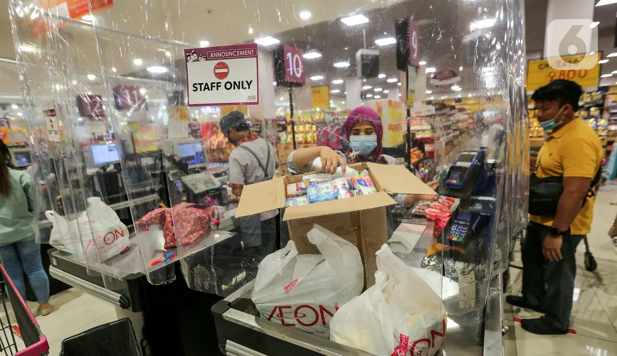 Kasir memasukan barang konsumen yang dibatasi dengan plastik di supermarket AEON Mall BSD City, Tangerang, Rabu (3/6/2020). Pembatasan tersebut dilakukan untuk memberikan jarak sosial dalam interaksi antara kasir dan konsumen selama pandemi Covid-19. (Liputan6.com/Fery Pradolo)
