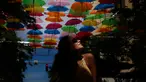 Julia Pena (19) dari Miami menikmati instalasi seni yang bernama Umbrella Sky di Coral Gables, Florida, 16 Juli 2018. Coral Gables merupakan kota ketiga di AS yang menjadi tuan rumah bagi instalasi seni yang berlangsung hingga Agustus. (AP/Brynn Anderson)