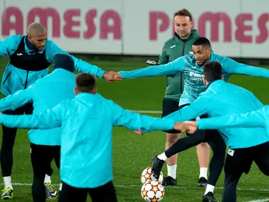 Gelandang Villarreal Etienne Capoue (kiri) dan rekan setimnya, Arnaut Danjuma menghadiri sesi latihan di Ciudad Deportiva Villarreal di Vila-Real, Senin (22/11/2021). Villarreal bakal menjamu Manchester United dalam lanjutan Liga Champions, Selasa (23/11) waktu setempat. (JOSE JORDAN / AFP)