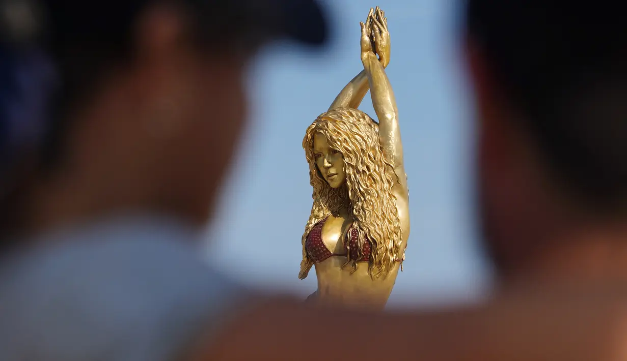 Wisatawan berfoto dengan patung Shakira di Malecon di Barranquilla, Kolombia, pada 26 Desember 2023. (STR / AFP)