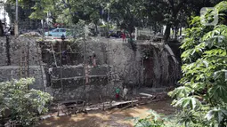 Suasana pengerjaan turap di bantaran Kali Kramat Jati, Jakarta, Jumat (20/1/2023). Pembangunan turap bertujuan untuk mencegah longsor yang dapat membahayakan warga sekitar. (Liputan6.com/Faizal Fanani)