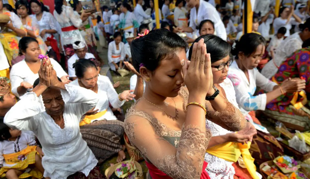 Salah seorang umat Hindu sedang berdoa di tengah perayaan hari raya Galungan di Jimbaran, Bali, Rabu (21/5/14). (AFP PHOTO/Sonny Tumbelaka)