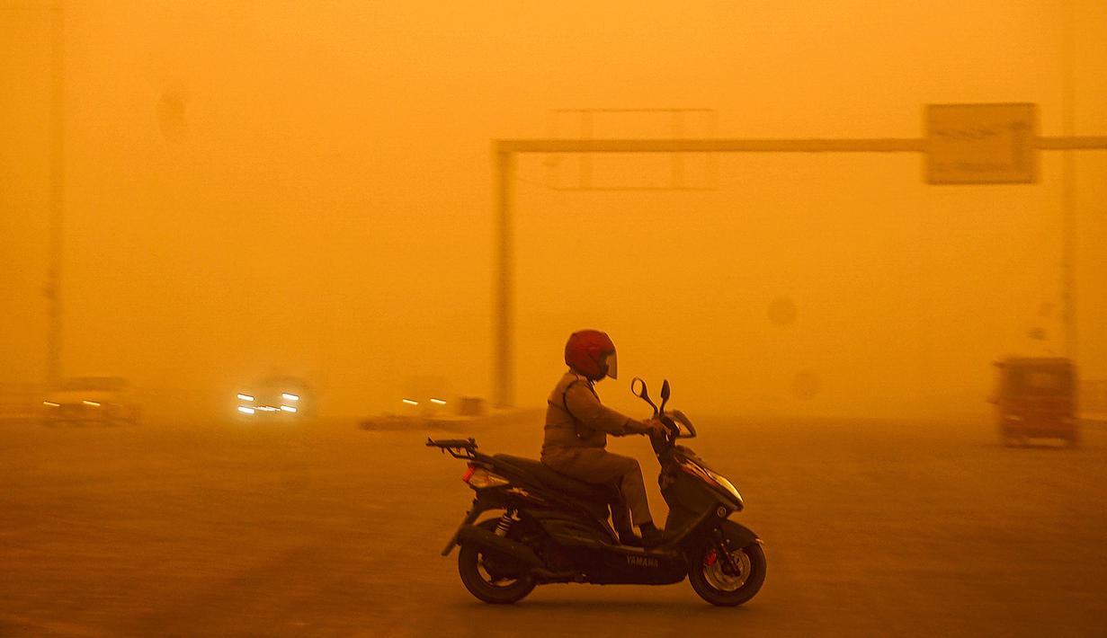 Seorang pengendara mengendarai skuter saat badai debu berat menghantam Baghdad, Irak, Senin (16/5/2022). (Sabah ARAR/AFP)