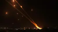Militan Palestina Hamas meluncurkan roket menuju Israel dari Rafah, di Jalur Gaza selatan, Rabu (12/5/2021) dinihari. Hamas menyatakan mereka telah menembakkan lebih dari 200 roket ke Israel sebagai pembalasan atas serangan di sebuah blok menara di Gaza. (SAID KHATIB / AFP)