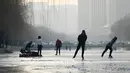 Sejumlah warga bermain ice skating di sungai yang membeku di Beijing, China (10/1). Akibat membeku, Sungai ini menjadi objek wisata dadakan. (AFP Photo/Wang Zhao)