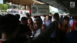 Sejumlah karyawan berkumpul di halte Bursa Efek Indonesia (BEI) saat balkon lantai 1 bangunan ambruk, Jakarta, Senin (15/1). (Liputan6.com/Johan Tallo)