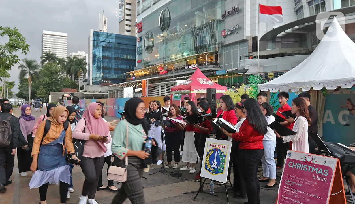 Suasana saat paduan suara Christmas Carol menghibur pengguna jalan di pedestrian kawasan Sudirman, Jakarta, Rabu (18/12/2019). Terdapat 11 titik Christmas Carol di sepanjang Jalan Sudirman – MH Thamrin dan stasiun MRT. (Liputan6.com/Herman Zakharia)