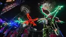Sejumlah wanita membawakan tarian phoenix yang dihiasi dengan lampu warna-warni di Gardens by the Bay, Singapura (4/2). Ornamen burung phoenix terlihat cantik dengan cahaya warna-warni. (AFP/Roslan Rahman)