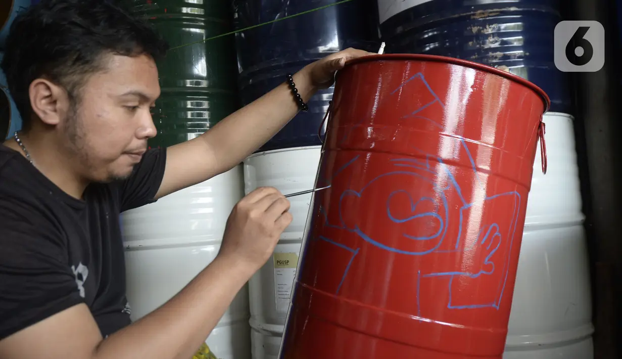 Faiz (21) melukis tong sampah dengan gambar tokoh kartun di Setu, Tangerang Selatan, Banten, Kamis (1/10/2020). Faiz mengecat ulang tong bekas dan melukisnya dengan tokoh-tokoh kartun, lalu menjualnya dengan harga Rp 85 hingga 120 ribu per unit. (merdeka.com/Dwi Narwoko)