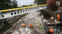 Petugas PPSU mencoba mengurai sampah yang menumpuk di Kali Cideng, Jakarta Pusat, Senin (11/9). Sempat disulap tertata rapi dan bersih, sampah plastik dan sampah rumah tangga kembali menumpuk hingga menghambat laju air. (Liputan6.com/Immanuel Antonius)
