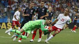 Kiper Kroasia, Danijel Subasic mengamankan bola dari kejaran pemain Denmark, Yussuf Yurary Poulsen pada laga 16 besar Piala Dunia 2018 di Nizhny Novgorod Stadium, Rusia, (1/7/2018). Kroasia menang 3-2 lewat adu penalti. (AP/Darko Bandic)