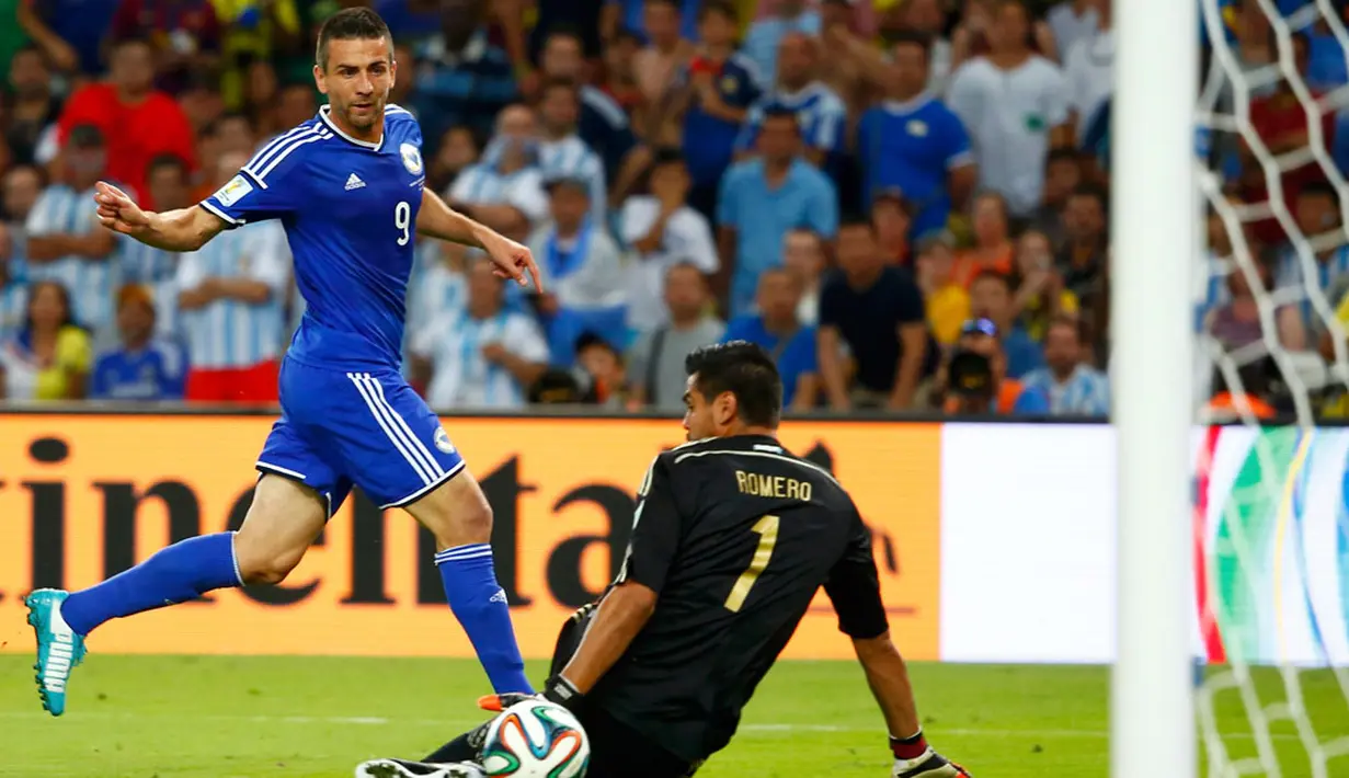 Pemain depan Bosnia-Herzegovina, Vedad Ibisevic (kiri) sukses mencetak gol ke gawang Argentina yang dikawal Sergio Romero di laga di penyisihan Piala Dunia 2014 Grup F di   Estadio do Maracana, Rio de Janeiro, Brasil, (16/6/2014). (AFP PHOTO/Tony Gentile)