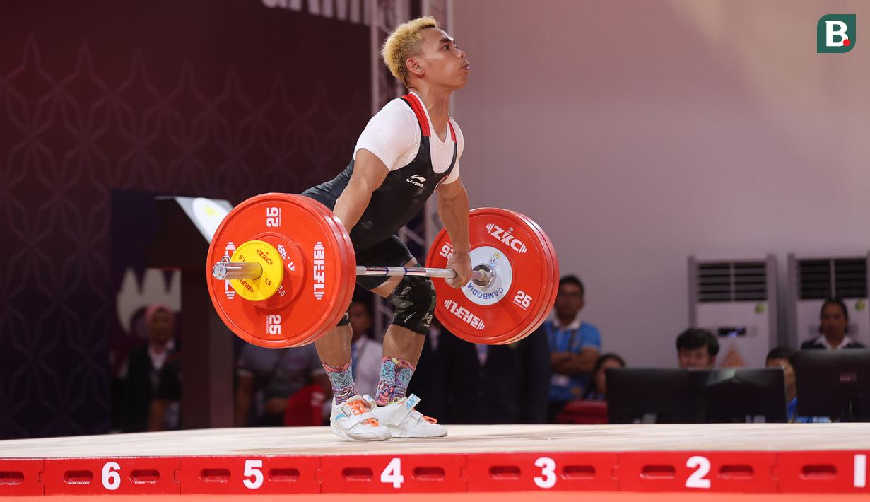 <p>Atlet angkat besi Indonesia, Eko Yuli Irawan berkompetisi pada nomor angkat besi putra 61 kg SEA Games 2023 di Taekwondo Hall Olympic Complex, Phnom Penh, Kamboja, Sabtu (13/05/2023). (Bola.com/Abdul Aziz)</p>