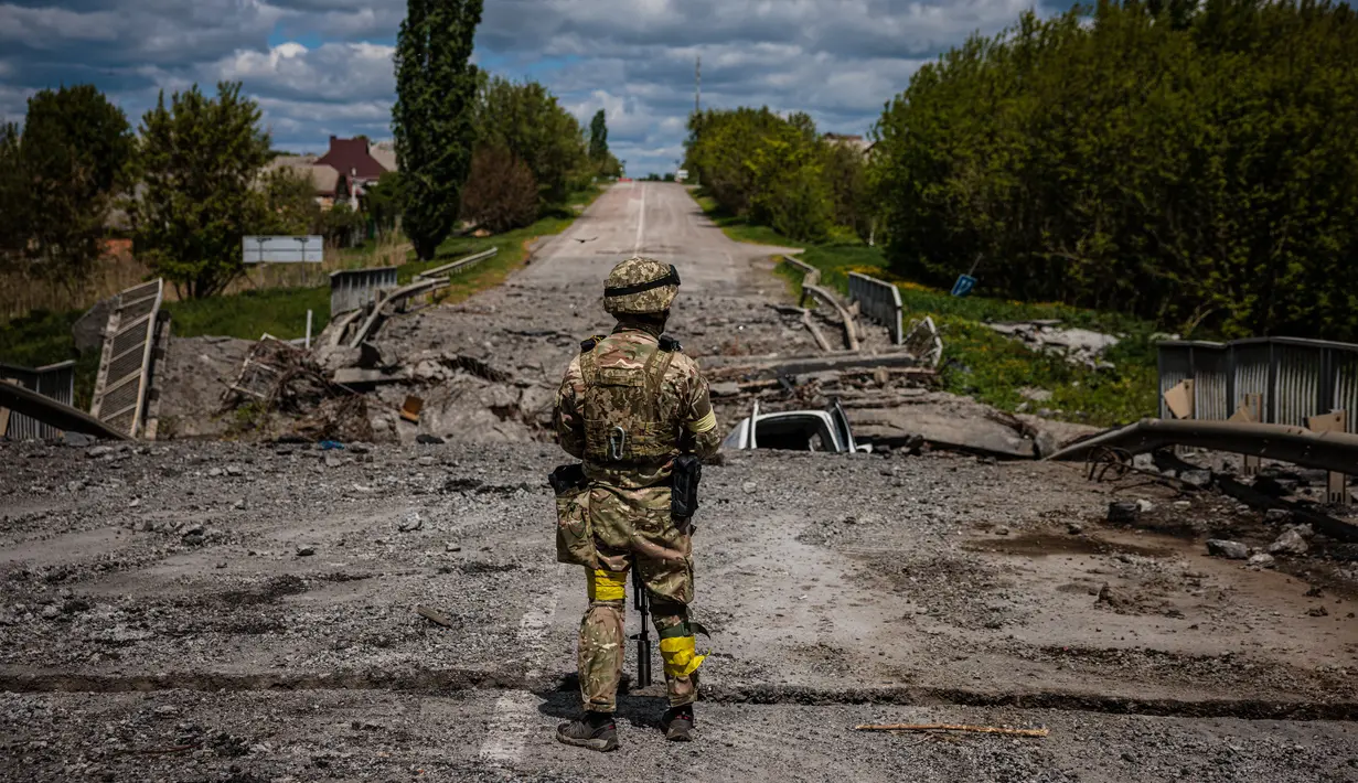 <p>Seorang tentara dari unit pasukan khusus Ukraina Kraken mengamati daerah di jembatan yang hancur di jalan dekat desa Rus'ka Lozova, utara Kharkiv, pada 16 Mei 2022. Ukraina mengatakan pasukannya telah menguasai kembali wilayah di Perbatasan Rusia dekat kota terbesar kedua di negara itu Kharkiv, yang terus-menerus diserang sejak invasi Moskow dimulai. (Dimitar DILKOFF / AFP)</p>