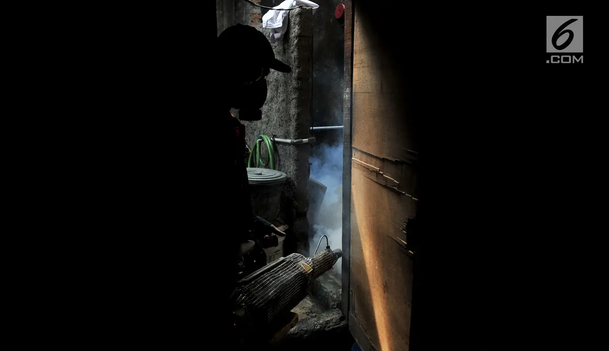 Petugas melakukan fogging nyamuk demam berdarah dengue (DBD) di salah satu rumah warga RW 01, Kelurahan Cipinang, Jakarta, Minggu (10/3). Fogging dilakukan setelah beberapa warga di permukiman tersebut terkena DBD. (merdeka.com/Iqbal Nugroho)