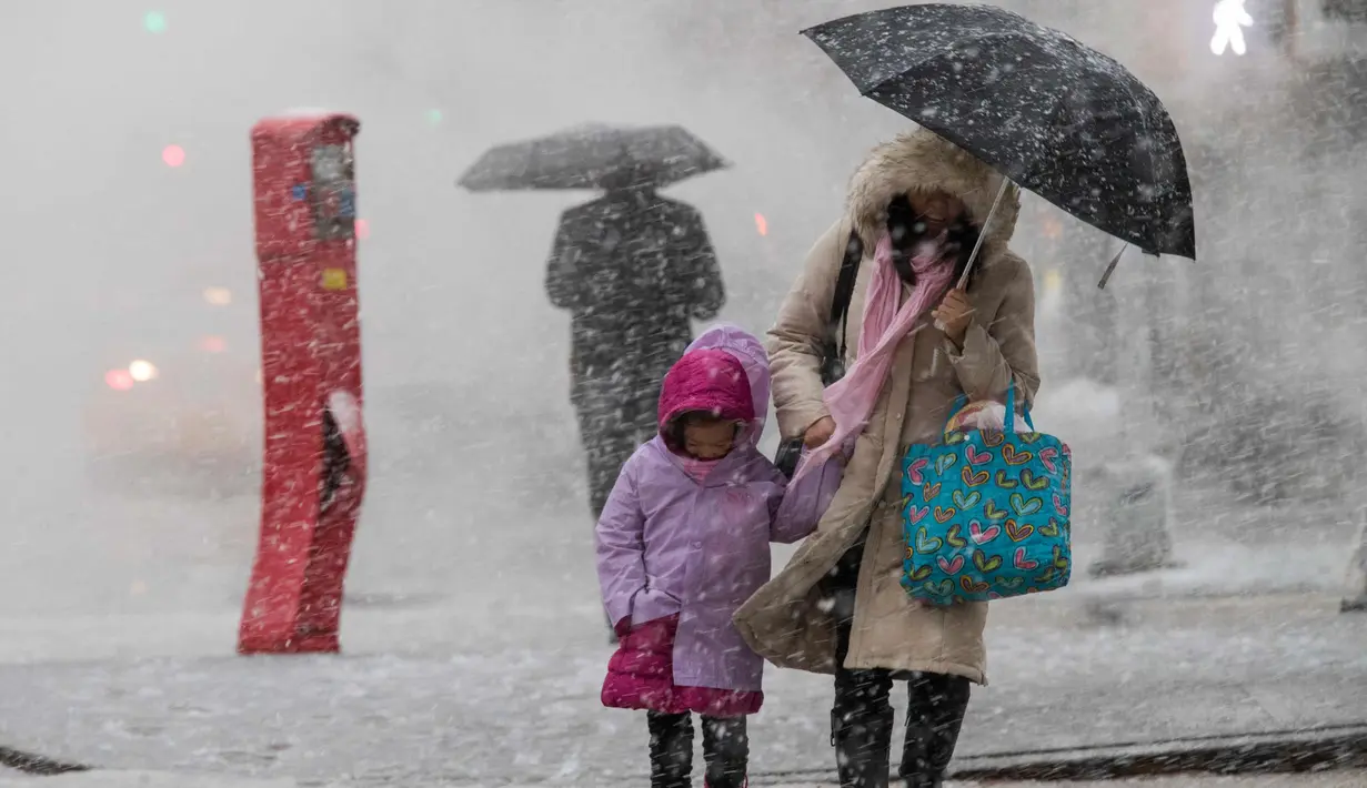 Pejalan kaki berjalan di sepanjang St. Delancey saat badai salju di New York (7/3). Badai salju kedua yang melanda New York dalam waktu seminggu ini diperkirakan akan membawa angin kencang. (AP Photo / Mary Altaffer)