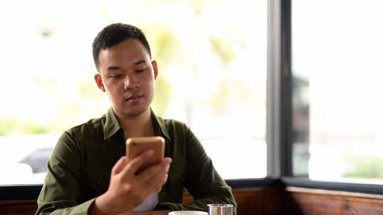 Seorang laki-laki yang terlihat bingung saat melihat saldo e-wallet