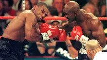 Mike Tyson dan Evander Holyfield kembali berduel di MGM Grand Garden Arena, Las Vegas pada 28 Juni 1997. Akan tetapi, laga akbar ini harus dihentikan pada ronde ketiga, karena Tyson menggigit kuping Holyfield. (AFP/JOHN GURZINSKI)