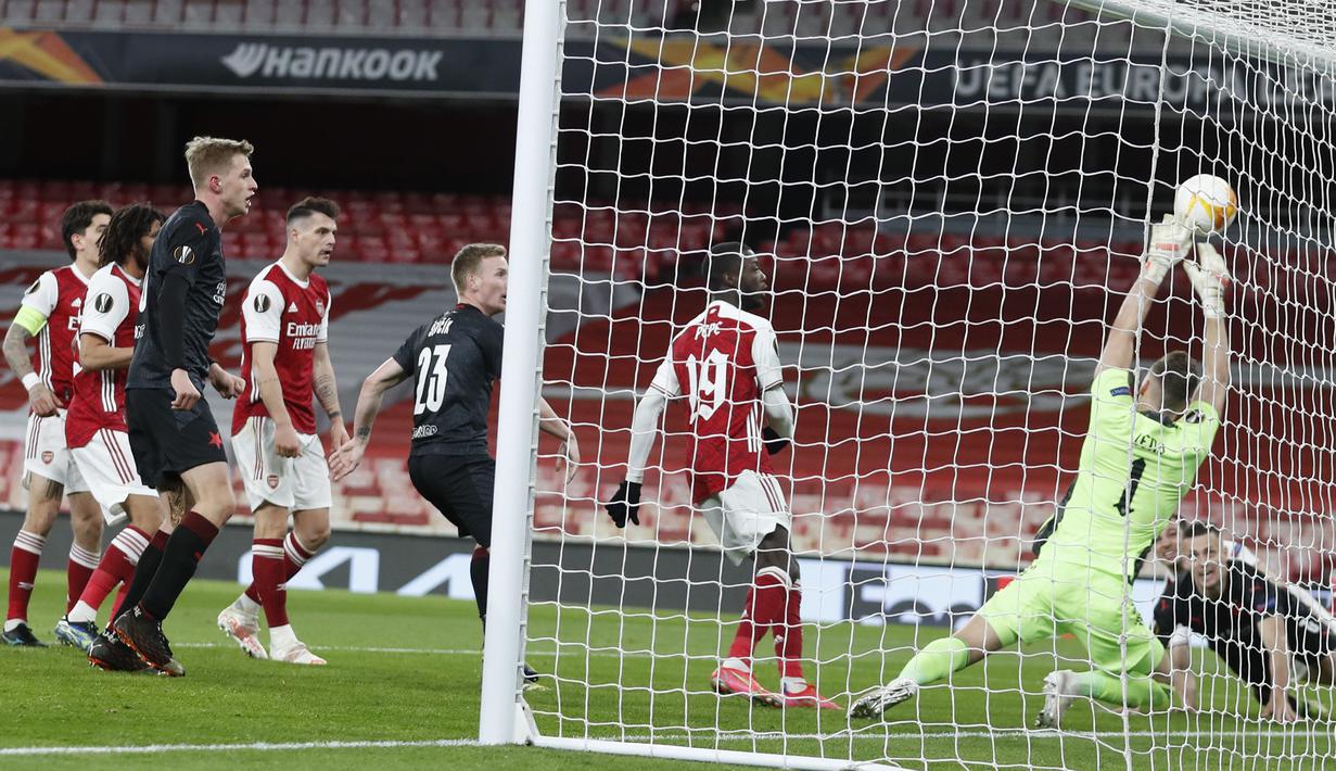 Bek Slavia Praha, Tomas Holes (kanan) melepaskan sundulan yang berbuah gol penyeimbang 1-1 ke gawang Arsenal dalam laga leg pertama perempatfinal Liga Europa 2020/2021 di Emirates Stadium, London, Kamis (8/4/2021). Slavia Praha bermain imbang 1-1 dengan Arsenal. (AP/Alastair Grant)
