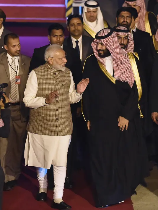 PM India, Narendra Modi menyambut kedatangan Putra Mahkota Arab Saudi Pangeran Mohammed bin Salman di bandara New Delhi, Selasa (19/2). Rencananya pembicaraan kerja sama bilateral akan dilakukan Modi dan Pangeran MBS pada Rabu (20/2). (Money SHARMA/AFP)