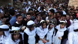Ratusan orang dari kelompok Yazidi Irak berkumpul di luar kuil Lalish untuk merayakan Tahun Baru Yazidi di lembah dekat Dohuk, Irak (17/4). Mereka adalah kelompok etnoreligius dan berbahasa Kurdi yang mempraktikkan agama sinkretisme. (AFP/Safin Hamed)