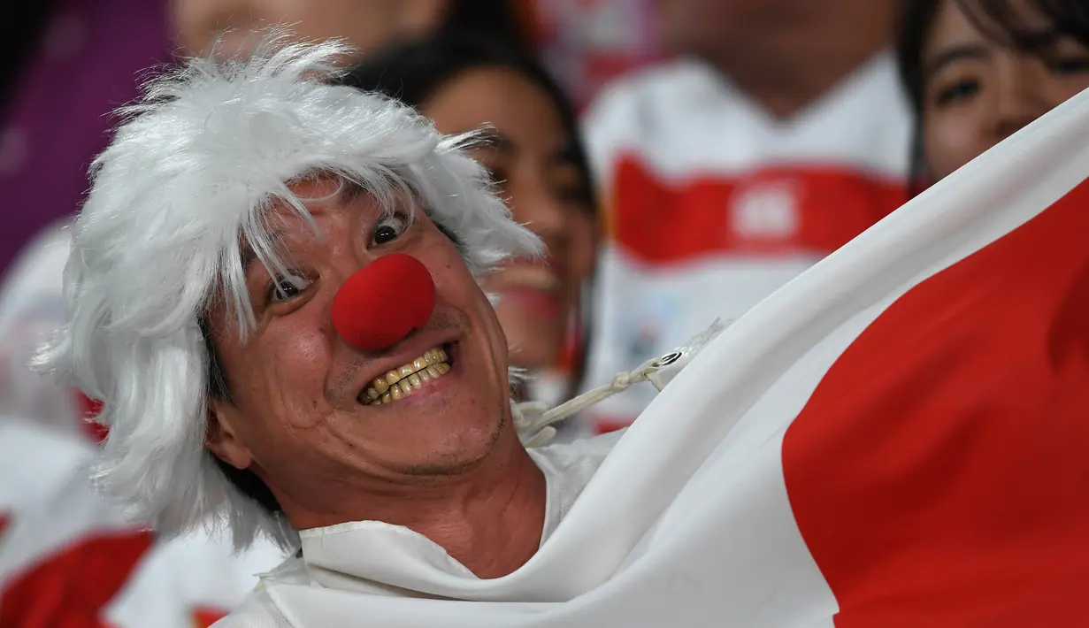 Seorang fans mengenakan rambut dan hidung palsu tersenyum sebelum pertandingan antara Rusia dan Jepang pada pembukaan Rugby World Cup Pool A  di Stadion Tokyo (20/9/201). Rugby World Cup diselenggarakan dari 20 September hingga 2 November 2019. (AFP Photo/Toshifumi Kitamura)