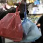 Warga menunjukkan barang belanjaan yang dibawa menggunakan kantong plastik sekali pakai di Pasar Tebet Barat, Jakarta, Kamis (6/2/2020). Masih banyak pedagang maupun pembeli yang menggunakan kantung plastik sebagai tempat bawaan membawa belanjaan. (merdeka.com/Iqbal S Nugroho)