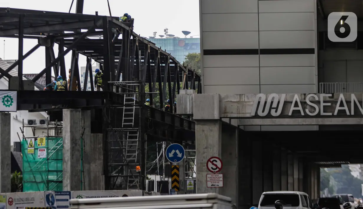 Pekerja menyelesaikan jembatan layang integrasi antara Stasiun MRT ASEAN dengan Halte Transjakarta CSW koridor 13, Jakarta, Rabu (8/1/2020). Jembatan layang ini nantinya akan memudahkan penumpang untuk mengakses salah satu moda transportasi baik MRT atau Transjakarta. (Liputan6.com/Faizal Fanani)