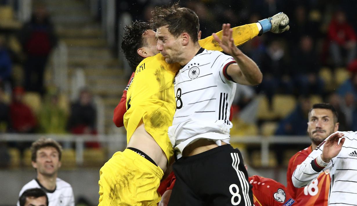 Kiper Makedonia Utara Stole Dimitrievski meninju bola melewati gelandang Jerman Leon Goretzka pada lanjutan Kualifikasi Piala Dunia 2022 zona Eropa Grup J di Tose Proeski National Arena, Selasa (12/10/2021) WIB. Jerman menghajar Makedonia Utara empat gol tanpa balas. (AP Photo/Boris Grdanoski)