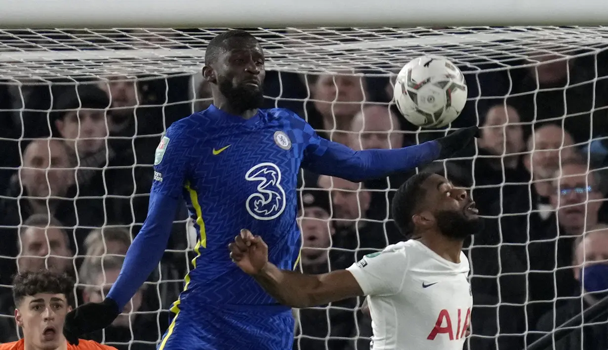 Bek Chelsea Antonio Rudiger melompat saat berebut bola dengan bek Tottenham Hotspur Japhet Tanganga dalam semifinal leg pertama Piala Liga Inggris di Stamford Bridge, Kamis (6/1/2022) dini hari WIB. Chelsea mengungguli Tottenham Hotspur 2-0. (AP Photo/Kirsty Wigglesworth)