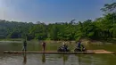 Warga bersama sepeda motornya menyeberangi Sungai Cisadane menggunakan rakit bambu di kawasan Ciseeng, Kabupaten Bogor, Jawa Barat, Kamis (11/6/2026). (merdeka.com/Arie Basuki)