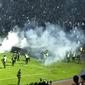 Aparat keamanan&nbsp;melepas tembakan gas air mata untuk menghalau massa dalam kerusuhan di Stadion Kanjuruhan Malang pada Sabtu, 1 Oktober 2022 (Liputan6.com/Zainul Arifin)