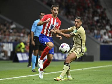 Bek Atletico Madrid #03 Cesar Azpilicueta bersaing dengan penyerang Granada #11 Myrto Uzuni pada pekan pertama Liga Spanyol 2023-2024 di Estadio Wanda Metropolitano pada Selasa (15/8/2023) dini hari WIB. (Photo by JAVIER SORIANO / AFP)