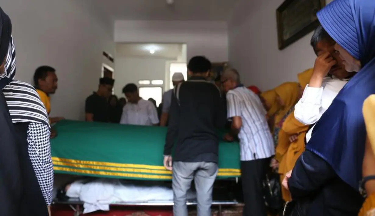 Tampak dipeluk salah seorang kerabatnya, tangan mungil Al Mukhti terus menutupi telinganya. Seakan anak laki-laki ini tak ingin mendengar tangisan dari para pelayat yang hadir saat itu. (Nurwahyunan/Bintang.com)