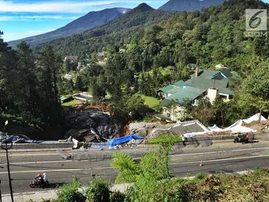 Pengendara motor melintasi kawasan longsor di Desa Ciloto, Kabupaten Cianjur, Jawa Barat, Kamis (29/3). Longsor di bahu Jalan Raya Puncak itu membuat arus lalu lintas ditutup sementara bagi pengendara roda empat. (Merdeka.com/Arie Basuki)