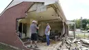 Brian Mitchell (kanan) melihat-lihat rumah ibu mertuanya yang rusak akibat banjir di Waverly, Tennessee, Minggu (22/8/2021). Sejumlah mobil dan rumah warga tersapu banjir di jalanan Waverly, kota yang berjarak sekitar 90 kilometer dari Nashville. (AP Photo/Mark Humphrey)