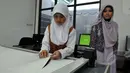 Salah satu pengajar mengawasi siswi yang sedang menggunting pola gaun muslim di sela-sela peresmian Sekolah Fashion SMK NU Banat, Kudus, Jawa Tengah, Rabu (11/3/2015). (Liputan6.com/Panji Diksana)