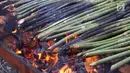 Proses pembakaran pakat di Jalan Letda Sudjono, Kota Medan, Sumatera Utara, Senin (28/5). Selama Ramadan, pedagang penganan khas Mandiling ini mampu menjual 50 hingga 60 ikat pakat. (Liputan6.com/Reza Perdana)