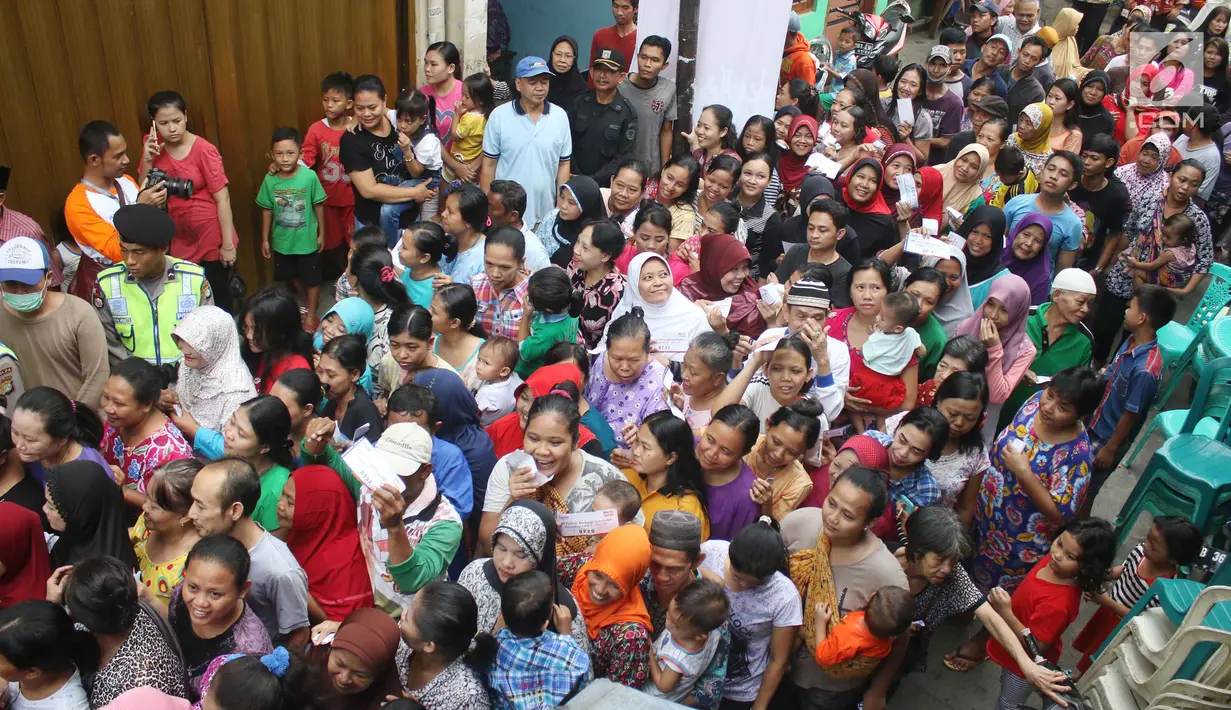 Antrean ratusan warga untuk mendapatkan paket sembako Ramadan di Kecamatan Penjaringan, Jakarta, Selasa (13/6). Paket sembako dibagikan gratis kepada masyarakat pra sejahtera sebagai bentuk kepedulian dan aksi sosial BUMN. (Liputan6.com/Angga Yuniar)