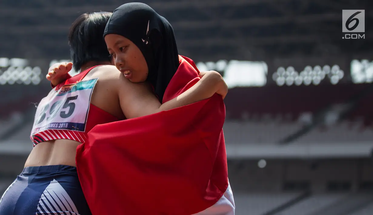 Pelari Indonesia, Tiarani Karisma Evi menghibur lawannya usai meraih medali emas Asian Para Games cabang atletik nomor lari 100 meter T42 / T63 di SUGBK, Jakarta, Rabu (10/10). (Bola.com/Vitalis Yogi Trisna)