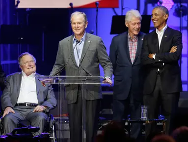 Mantan Presiden George W. Bush (tengah) didampingi empat mantan Presiden AS lainnya berpidato dalam acara konser amal di College Station, Texas (21/10). (AP Photo/LM Otero)