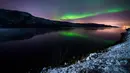 Cahaya berwarna kehijaun tampak menerangi langit malam saat fenomena aurora borealis di dekat kota Kirkenes, Norwegia utara, Kamis (12/11/2015). (AFP PHOTO/Jonathan NACKSTRAND)