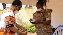 Pengunjung membersihkan tangan dengan cairan disinfektan di pintu masuk Pusat Pendidikan Konservasi Margasatwa Uganda (UWEC) di Entebbe, 9 Agustus 2020. Uganda membuka kembali UWEC untuk wisatawan saat negara di Afrika Timur itu melonggarkan kebijakan lockdown. (Xinhua/Nicholas Kajoba)