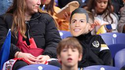 Seorang suporter mengenakan topeng Cristiano Ronaldo saat menyaksikan laga Grup F Kualifikasi Piala Dunia 2026 antara Portugal melawan Armenia di Dragao Stadium, Porto, Minggu (16/11/2025) waktu setempat. (AP Photo/Luis Vieira)