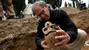 Arkeolog menunjukkan tengkorak saat penggalian kuburan massal korban Perang Saudara Spanyol di El Carmen, Valladolid, (9/5). Penggalian ini dimulai sejak 2014 dan diharapkan selesai tahun ini. (REUTERS/Juan Medina)