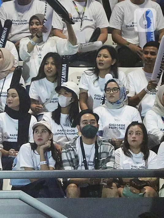 Mereka berdua duduk di tribun bersama pendukung tim putih. (Fimela.com/Bambang E Ros)