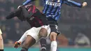 Penyerang AC Milan, Mario Balotelli (kiri) berebut bola udara dengan bek Inter Milan, Joao Miranda pada Liga Italia di Stadion San Siro, Milan (31/01/2016). AC Milan menang telak atas Inter Milan dengan skor 3-0. (REUTERS/Alessandro Garofalo)