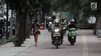 Sejumlah pengendara sepeda motor nekat menaiki jalur trotoar untuk menghindari kemacetan di Jalan Casablanca, Jakarta, Senin (8/1) (Liputan6.com/Arya Manggala Nuswantoro)